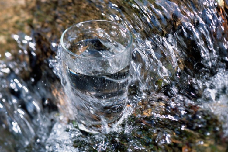 Vaso de agua lleno en un riachuelo